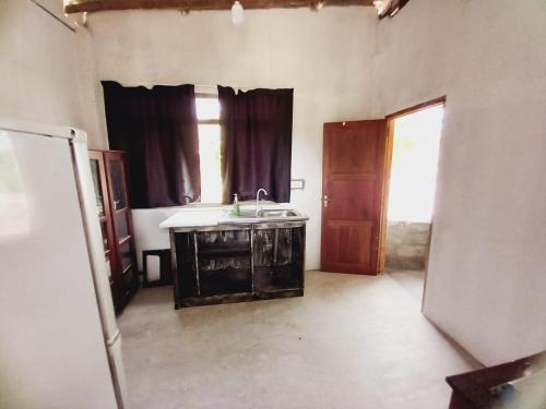 una cocina vacía con fregadero y ventana en Asanka Beach Stay, en Mirissa