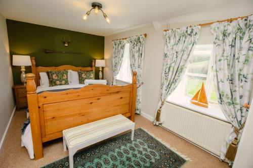 a bedroom with a wooden bed and a window at Carters Cottage - Rudge Farm Cottages in Bridport