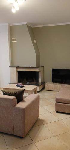 a living room with a couch and a fireplace at Mountainside in Vounoplagiá