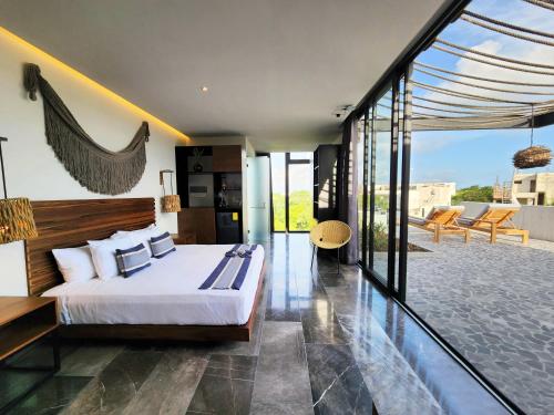 Un dormitorio con una cama y un balcón. en Iik Tulum Luxury Penthouses by Spot Rentals, en Tulum