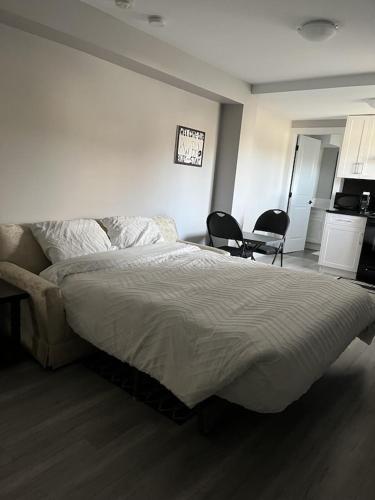 a bedroom with a large bed and two chairs at Brand new, One bedroom, two bed separated suite. in Victoria