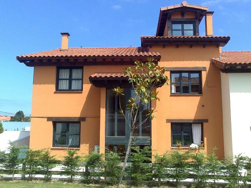 a large orange house with a tree in front of it at Duplex Colombres in Colombres