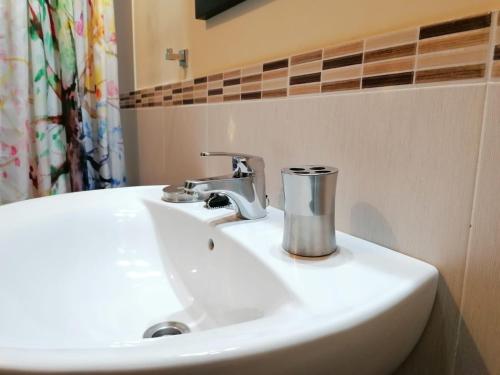 a white bathroom sink with a chrome faucet at Duplex Colombres in Colombres