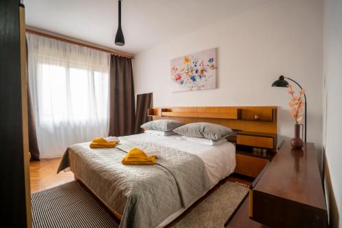 a bedroom with a bed with two yellow towels on it at Apartment SOUL in Knin