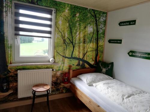 a bedroom with a tree mural on the wall at Ferienwohnung Isis in Neufang in Sonneberg