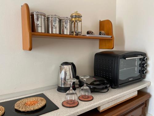 w kuchni znajduje się kuchenka mikrofalowa i toster. w obiekcie Beachfront Studio Socrates w mieście Jenadi