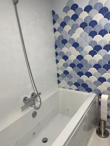 a bath tub in a bathroom with a blue and white wall at Apartamento Maitika in Santander