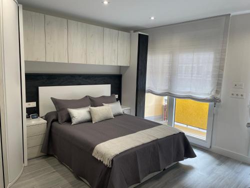 a bedroom with a large bed and a window at Apartamento Maitika in Santander