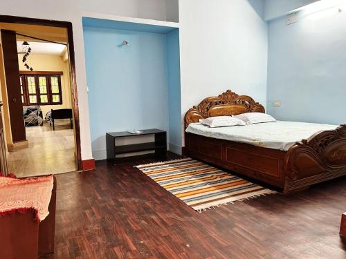 sypialnia z dużym łóżkiem i drewnianą podłogą w obiekcie Garden Central - 2 Bedroom Apartment, Siliguri w mieście Siliguri