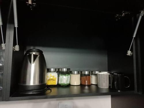 a kitchen counter with spices and a tea kettle at moderno apartamento en el centro de la ciudad in Chihuahua