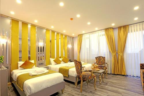 a hotel room with two beds and a table and chairs at Santa Rio Taxim in Istanbul