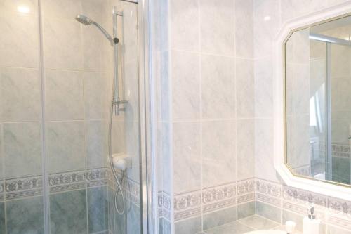 a bathroom with a shower and a sink and a mirror at Spacious North Devon villa with beautiful garden in Bideford