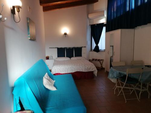 a bedroom with a bed and a blue couch at Petronilla in Fermo