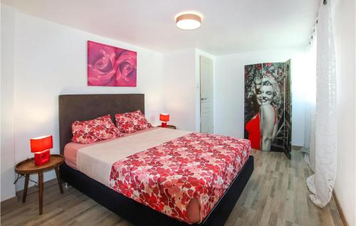 a bedroom with a bed and two paintings on the wall at Beautiful Apartment In Gemenos With Outdoor Swimming Pool in Gémenos