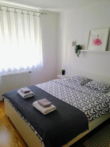 a bedroom with a large bed with towels on it at Apartment Nina in Varaždin