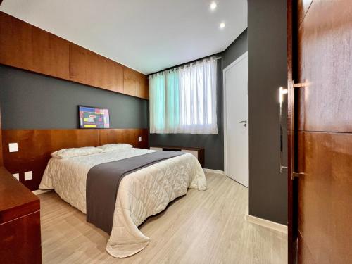 um quarto com uma cama e uma janela em Flat em região nobre em Belo Horizonte