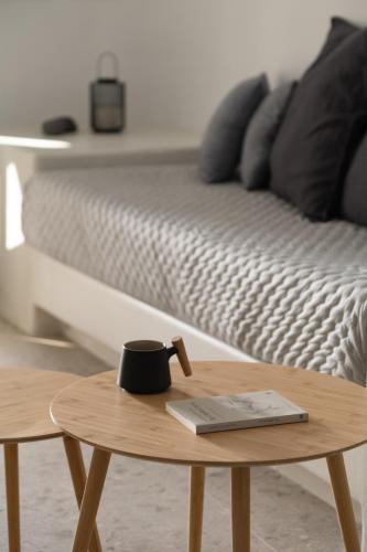 a coffee cup on a table next to a bed at Nisó Cave Suites in Megalokhori