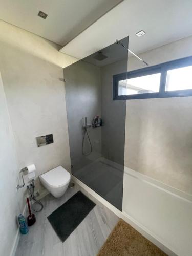a bathroom with a shower and a toilet and a window at rainbow house 