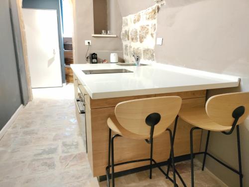 a kitchen with a sink and two stools at Mina Boutique in Jerusalem