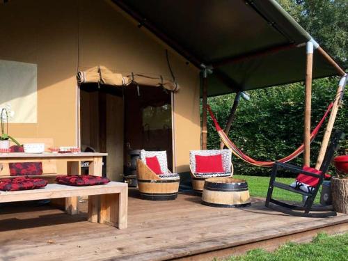 a gazebo with chairs and a bench and a table at Kampari in Delfstrahuizen