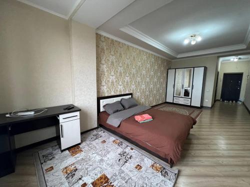 ein Schlafzimmer mit einem großen Bett und einem Schreibtisch in der Unterkunft apartment on Turusbekova 13 in Bischkek