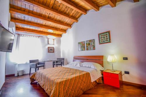 een slaapkamer met een bed en een tafel met stoelen bij Case Ruggero in Cefalù
