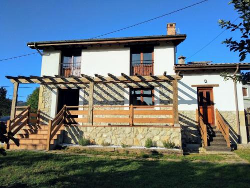 an old house with a wooden porch and stairs at La Quintana de Mary in Aramil de Arriba