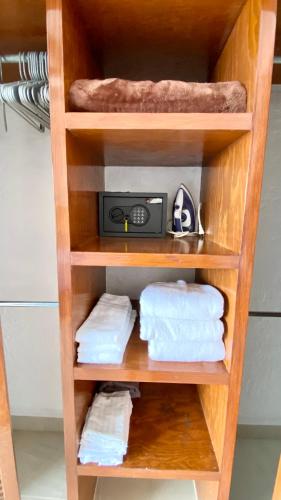 a wooden shelf with towels and a radio in a bathroom at San Angel Villas in San Antonio