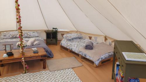 um quarto com duas camas numa tenda em Calon Y Goedwig Glamping em Llandovery