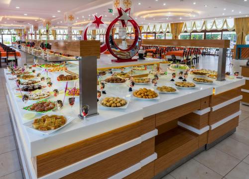 ein Buffet mit vielen Tellern voller Essen in der Unterkunft Club Hotel Belpınar-Beldibi-Kemer in Beldibi