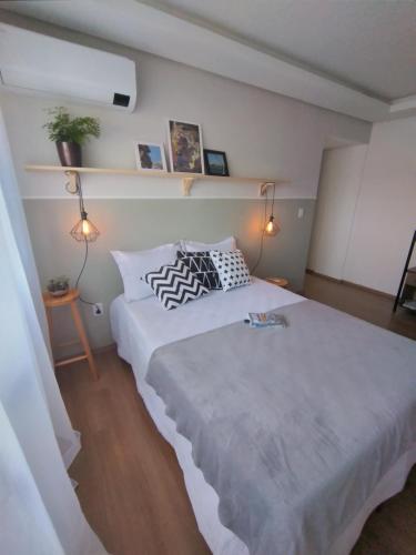 a bedroom with a large white bed with two pillows at HO1016 in Porto Alegre