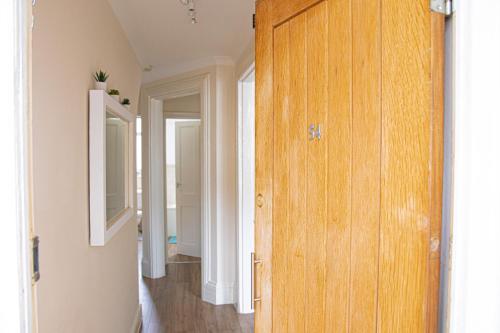 Habitación con puerta de madera y pasillo. en Central Dover Apartment 1, en Kent