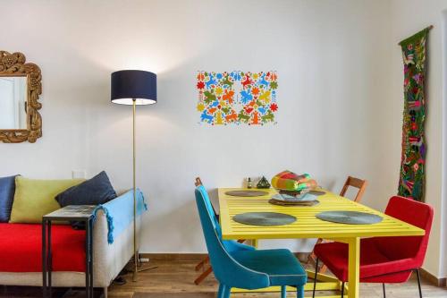 ein Esszimmer mit einem gelben Tisch und Stühlen in der Unterkunft Casa Flor de Mayo - fibreoptic internet, dishwasher, washer, dryer & AC in Puerto Morelos