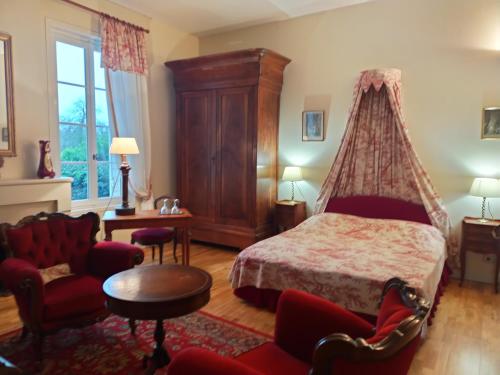 a bedroom with a bed with a canopy at Château Le Baudou in Coutras