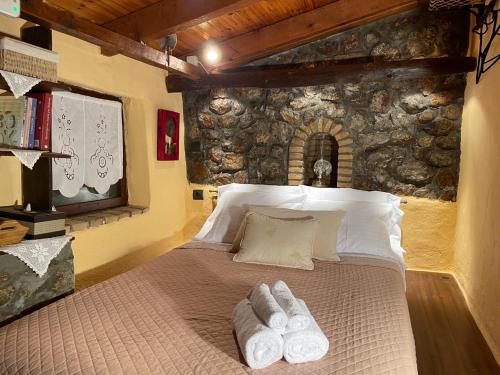 Agoriani Art Studio - Sweet little cottage في Lílaia: غرفة نوم عليها سرير وفوط