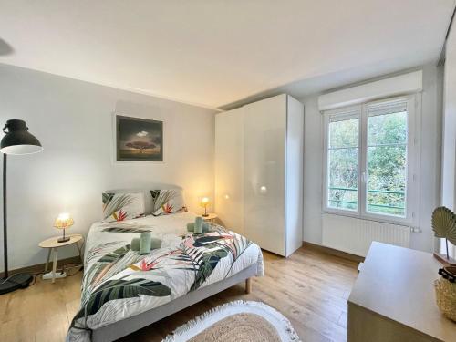 a bedroom with a bed and a table and a window at LA LOUSIANE - Confort - Wifi - Parking privé - Terrasse - Centre Ville in Quimper