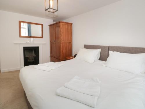 2 weiße Betten in einem Zimmer mit Kamin in der Unterkunft Grants Cottage in Dartmouth