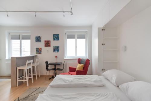 1 dormitorio con 1 cama, mesa y sillas en Im Herzen von Wien - Charmante Garconiere, en Viena