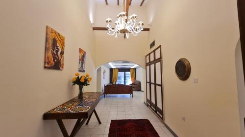 pasillo con mesa y lámpara de araña en Unique Furnished Holiday Villa Bahrain 