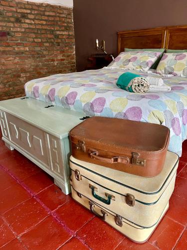 two pieces of luggage sitting next to a bed at GABRY GUEST HOUSE in Bruno