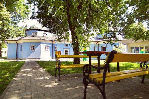 a yellow park bench in front of a building at Hotel Kardial in Teslić
