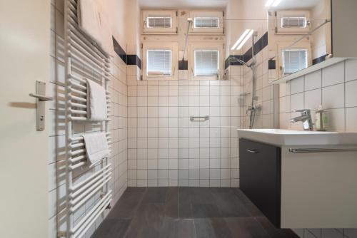 a white bathroom with a sink and a mirror at Im Herzen von Wien in Vienna