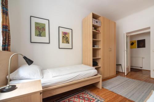 a bedroom with a bed and a book shelf at Im Herzen von Wien in Vienna