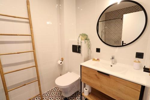 ein Badezimmer mit einem WC, einem Waschbecken und einem Spiegel in der Unterkunft Oleza Sun Playa Flamenca in Playa Flamenca
