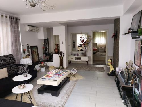 Guesthouse Hygge في تيرانا: غرفة معيشة مع أريكة وطاولة