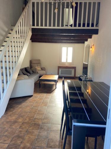 un salon avec une table et un escalier dans l'établissement Maison a 5 min des plages, à Six-Fours-les-Plages