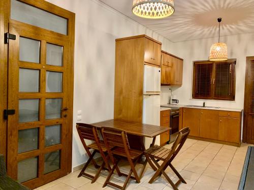 cocina con mesa de madera y sillas en Aggelos and Thisbe Chania Suburbs Sea View Guest House, en La Canea