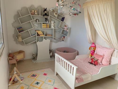 Un dormitorio de niños con una cuna blanca con una muñeca. en Appartement CANNES, vue mer triples exposition, en Cannes