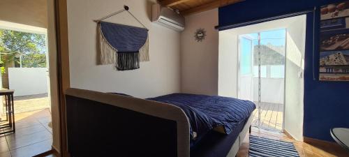 1 dormitorio con 1 cama y puerta al porche en Beautiful house in stunning nature, 22 minutes from beaches, 5 minutes to lake, air condition cool and heat, and very fast Internet in all rooms, dishwasher, washing machine and induction cooking, en Silves