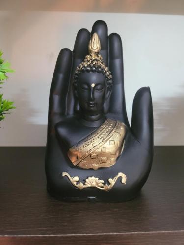 a statue of a buddha sitting on a table at Dhairya's Villa Home Away From Home in Jammu